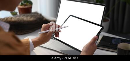 Primo piano di un uomo d'affari che tiene la penna dello stilo rivolto verso lo schermo vuoto del tablet digitale. Foto Stock