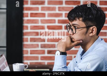 Imprenditore asiatico di Woking con il computer portatile e il foglio di lavoro sulla scrivania in ufficio.workflow digitale business online il concetto di stile di vita Foto Stock