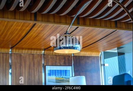 Primo piano di paralume arrotondato in acciaio inox e soffitto e parete decorati in legno. Interno della prefettura di polizia Hauts-de-Seine edificio. Foto Stock