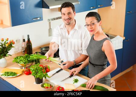 L uomo e la donna in cucina - essi preparare le verdure e insalate per pranzo o cena Foto Stock