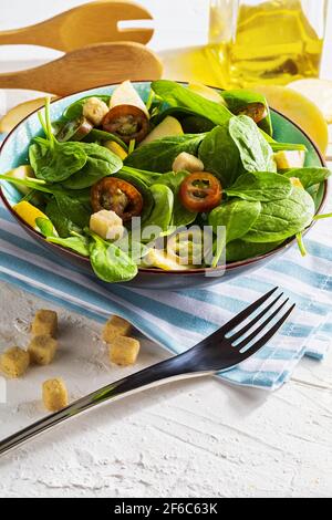 Appetitosa e salutare insalata vegetariana a basso contenuto calorico con germogli di spinaci, mela fresca, pomodori e toast. Dieta mediterranea. Look fatto in casa. Con COP Foto Stock