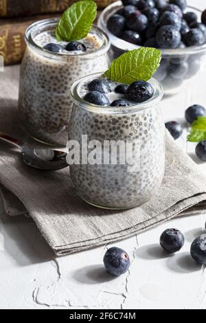 Budino di semi di chia appetitoso, sano e rinfrescante con mirtilli freschi e foglie di menta. Cibo vegetariano e vegano con cibi salutari. Homema Foto Stock