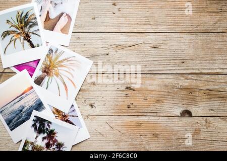 Pila di foto tropicali di vacanza stampate su sfondo di legno. Concetto di memorie felici. Tutte le foto mi appartengono. Vista dall'alto. Spazio di copia. Foto Stock