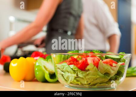 L uomo e la donna in cucina - essi preparare le verdure e insalate per pranzo o cena Foto Stock