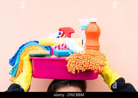 donna caucasica che tiene il bacino con i rifornimenti di pulizia Foto Stock
