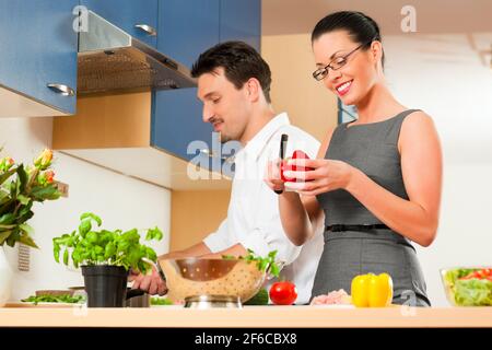 L uomo e la donna in cucina - essi preparare le verdure e insalate per pranzo o cena Foto Stock