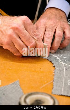 Mani di un sarto italiano che misura un vestito su misura Foto Stock