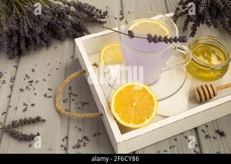 Tè alla lavanda con miele e limone sul legno bianco vassoio Foto Stock