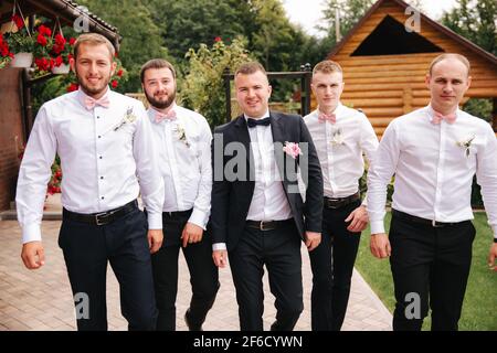 Groomsman elegante con lo sposo in piedi sul cortile e prepararsi per la cerimonia nuziale. Amico passare il tempo insieme fuori Foto Stock