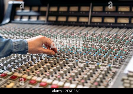 Foto di scorta di una persona non riconosciuta che utilizza il pannello di controllo in uno studio musicale professionale. Foto Stock