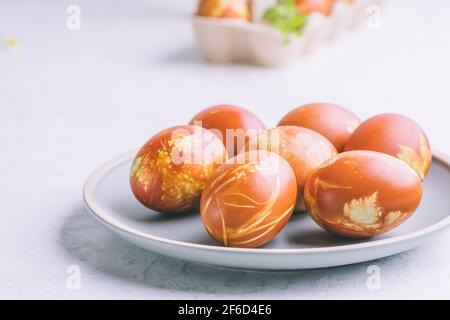 Tavolo per il brunch di Pasqua. Uova di Pasqua tinte naturali con conchiglie di cipolla e piante primaverili, vita sostenibile, celebrat vacanze di primavera eco-friendly Foto Stock