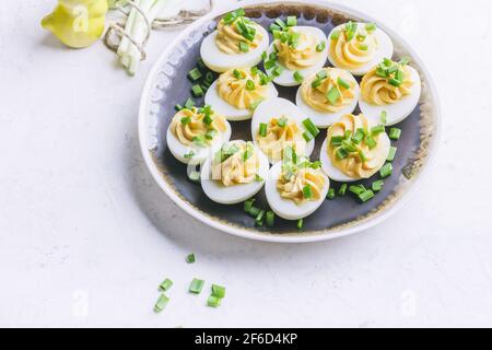 Uova deviled in piatto rustico di ceramica, spuntino di Pasqua brunch, primo piano Foto Stock