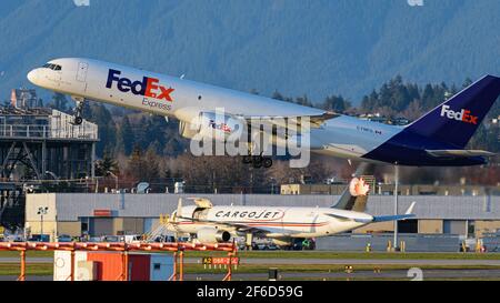 Richmond, British Columbia, Canada. 29 marzo 2021. Un cargo aereo FedEx Express Boeing 757-2B7(SF) (C-FMFG), di proprietà e gestito da Morningstar Air Express, decolli dall'aeroporto internazionale di Vancouver, Richmond, B.C. lunedì 29 marzo 2021. In background viene caricato un Cargojet Boeing 757. Credit: Bayne Stanley/ZUMA Wire/Alamy Live News Foto Stock