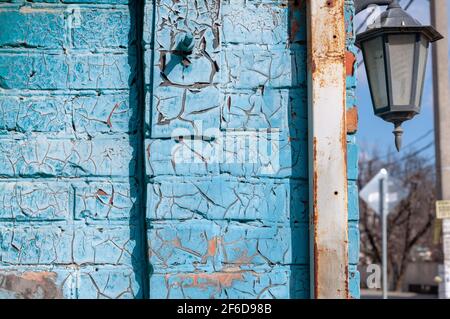 Vernice blu incrinata su una parete di mattoni. Consistenza della vecchia vernice incrinata. Metallo arrugginito. Foto Stock
