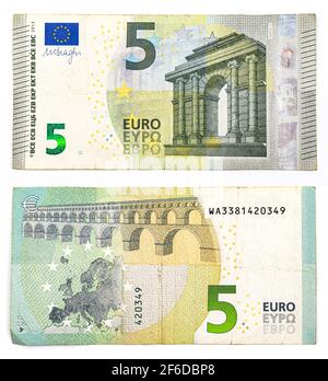 Vista ravvicinata di due lati di un conto di cinque euro su sfondo bianco isolato Foto Stock