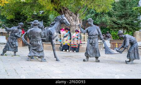 Shangrila Cina , 10 ottobre 2020 : due donne in abito tradizionale nel mezzo di statue nella strada della città vecchia di Dukezong Shangri-la Yunnan Cina Foto Stock