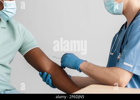 Mano del medico che inietta il vaccino del coronavirus covid-19 Foto Stock