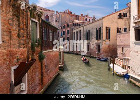 VENEZIA, 23 MAGGIO 2017: Tradizionale strada a canale stretto con gondole e vecchie case a Venezia. Architettura e monumenti di Venezia Foto Stock