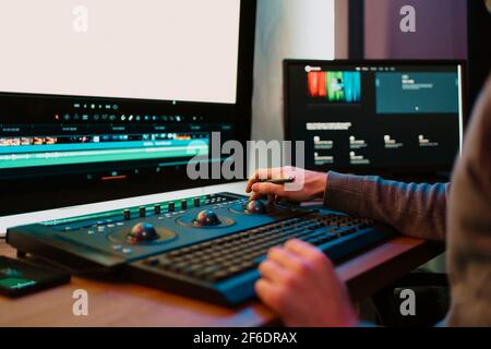 Male Video Editor Hands lavora con filmati o video sul suo pannello di controllo del Personal computer, lavora in Creative Office Studio o a casa. Luci al neon Foto Stock