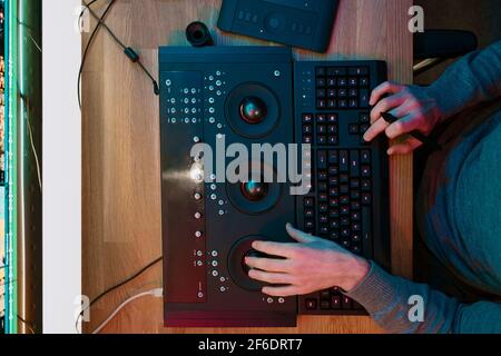 Male Video Editor Hands lavora con filmati o video sul suo pannello di controllo del Personal computer, lavora in Creative Office Studio o a casa. Luci al neon Foto Stock