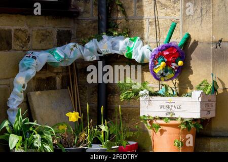 Honley, Holmfirth, Yorkshire, Regno Unito, 31 marzo 2021. Il bruco molto affamato in un giardino dei residenti, parte del percorso del libro intrecciato di Honley. Utilizzando materiali eco-friendly e riciclati, come i vecchi vestiti/tessuti, gli abitanti del villaggio e le aziende hanno creato una scena o un personaggio da un libro preferito da esporre nel loro giardino o finestra, per creare un percorso locale da Domenica 28 marzo a Lunedi 5 aprile. Questo evento fa parte del Festival della letteratura di Huddersfield e offre premi per i vincitori della zona e un hamper letterario/faodie per un vincitore assoluto. RASQ Photography/Alamy Live News. Foto Stock