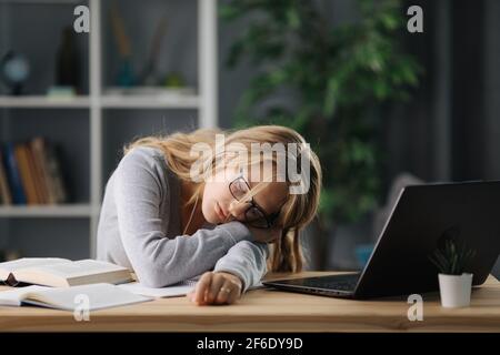 Studentessa di dormire sulla scrivania Foto Stock