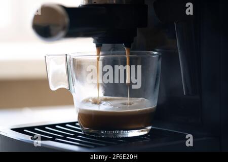 Macchina per caffè espresso in una tazza trasparente in vetro. Espresso caldo nella tazza - immagine Foto Stock