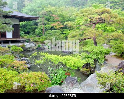 Una vista del tempio con giardini e laghetto. In una giornata grigia, piovosa e nebbiosa al tempio di Ginkaku-ji a Kyoto, Giappone. Foto Stock