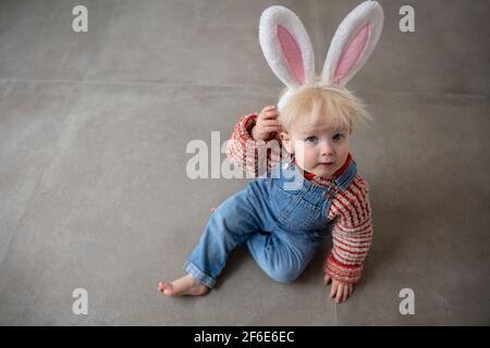 Carino bambino piccolo che celebra Pasqua indossando orecchie coniglietto di pasqua Foto Stock