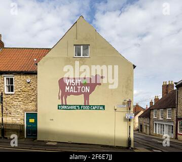 Visita il murale di Malton su una parete esterna in un negozio a Malton, North Yorkshire, Regno Unito. Foto Stock