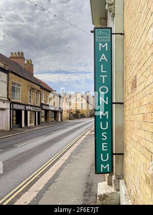 Cartello esterno del Malton Museum che guarda lungo Yorkergate verso il Talbot Hotel, Malton. North Yorkshire, Regno Unito. Foto Stock