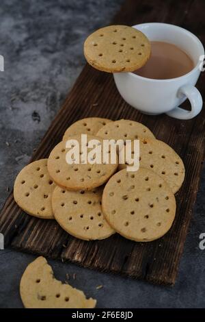 Biscotti indiani atti fatti in casa - biscotti interi di grano serviti con tè, fuoco selettivo Foto Stock