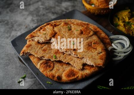 Naan di grano integrale - pane piatto indiano servito con korma di pollo, fuoco selettivo Foto Stock