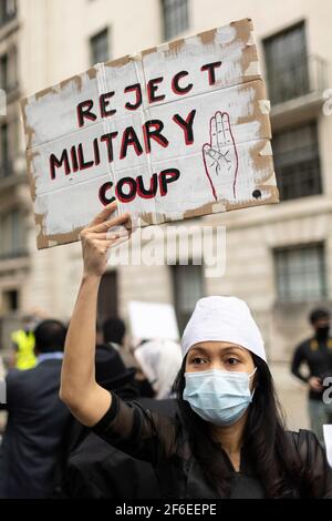 Londra, Regno Unito. 31 Marzo 2021. Una protesta femminile tiene un cartello con la scritta "Rifiuta colpo di Stato militare" fuori dall'ambasciata cinese. I manifestanti si sono riuniti in Piazza del Parlamento - indossando maschere facciali e osservando le distanze sociali - prima di marciare all'ambasciata cinese in solidarietà con il popolo del Myanmar contro il colpo di stato militare e le uccisioni di civili. I discorsi sono stati fatti fuori dall'ambasciata. Dall'inizio del colpo di stato militare del 1° febbraio, oltre 520 persone sono state uccise in Myanmar dalle forze di sicurezza. Sabato scorso è stato il giorno più violento in cui più di 100 persone sono stati kil Foto Stock