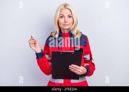 Ritratto della persona amichevole tenere la mano clipboard penna guardare attentamente telecamera isolata su sfondo grigio Foto Stock