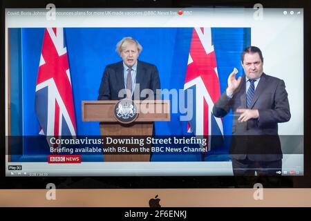 Boris Johnson affiancato da Union Jacks nella nuova sala stampa di Downing Street che fornisce un briefing di Covid. Notizie della BBC. Foto Stock