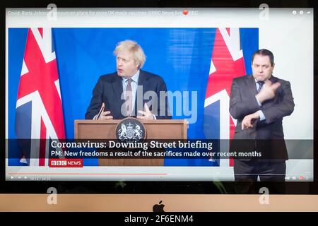Boris Johnson affiancato da Union Jacks nella nuova sala stampa di Downing Street che fornisce un briefing di Covid. Notizie della BBC. Foto Stock