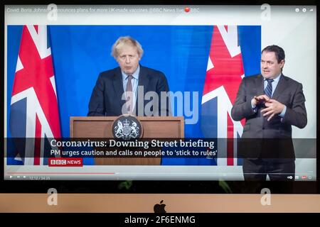 Boris Johnson affiancato da Union Jacks nella nuova sala stampa di Downing Street che fornisce un briefing di Covid. Notizie della BBC. Foto Stock