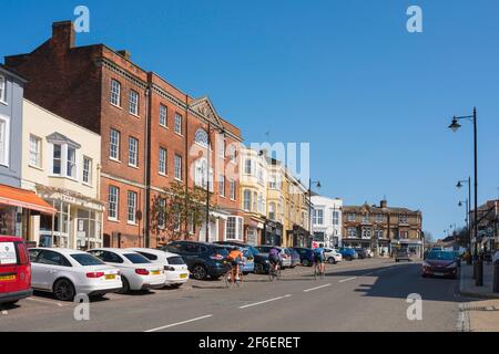 Halstead Essex UK, vista in estate dei ciclisti che cavalcano la High Street nel centro della città Essex di Halstead, Regno Unito. Foto Stock