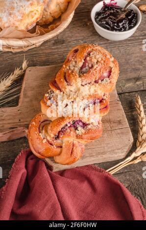 Prodotti da forno freschi - delizioso panino in vimini con ripieno sfondo di legno Foto Stock