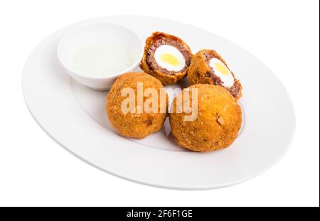Uova di scotch al forno con salsa tartar. Isolato su sfondo bianco. Foto Stock