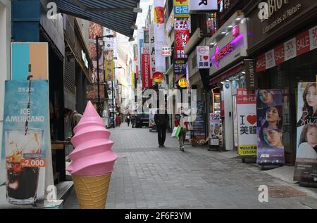 Coppia a piedi lungo il viale commerciale a Myeongdong, Seoul Foto Stock