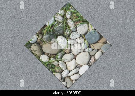 Sfondo grigio astratto composito su una parete intonacata con un inserto quadrato di pietre lisce di varie forme, per l'uso come sfondo senza giunture. Foto Stock