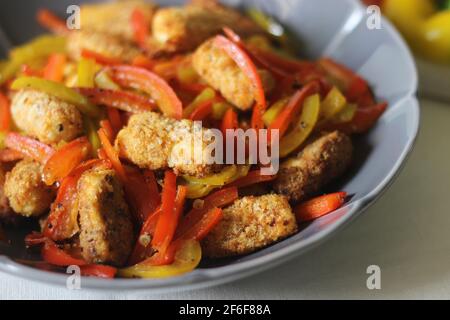 Pepite da paneer. Formaggio di cottage impanato e fritto all'aria servito con peperoni saltati, cipolle fresche tritate e jalapenos. Scatto su sfondo bianco Foto Stock