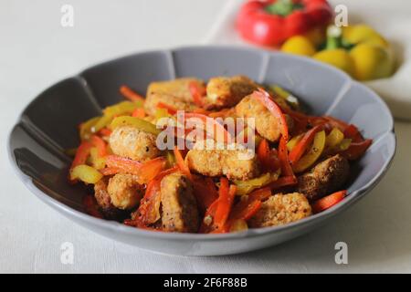 Pepite da paneer. Formaggio di cottage impanato e fritto all'aria servito con peperoni saltati, cipolle fresche tritate e jalapenos. Scatto su sfondo bianco Foto Stock