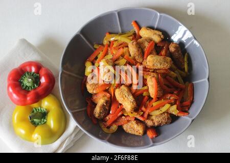 Pepite da paneer. Formaggio di cottage impanato e fritto all'aria servito con peperoni saltati, cipolle fresche tritate e jalapenos. Scatto su sfondo bianco Foto Stock