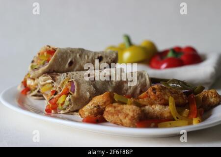 Panini al peperone. Formaggio di cottage impanato e fritto all'aria, peperoni saltati, cipolle fresche tritate e jalapenos arrotolati in tutto il grano indiano Foto Stock