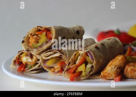 Panini al peperone. Formaggio di cottage impanato e fritto all'aria, peperoni saltati, cipolle fresche tritate e jalapenos arrotolati in tutto il grano indiano Foto Stock