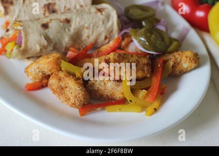 Panini al peperone. Formaggio di cottage impanato e fritto all'aria, peperoni saltati, cipolle fresche tritate e jalapenos arrotolati in tutto il grano indiano Foto Stock