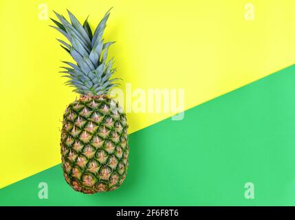 Ananas fresco di frutta tropicale su carta verde e gialla. Foto Stock